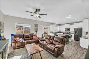 Living room with ceiling fan and light hardwood / wood-style floors