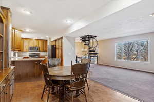 Dining area with sink, a textured ceiling, and carpet