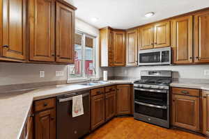 Kitchen with stainless steel appliances, sink, and light hardwood / wood-style flooring