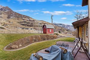 View of yard featuring a patio, a mountain view, and a shed