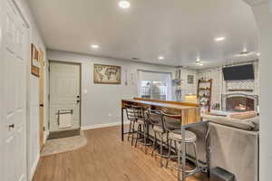 Kitchen with a kitchen bar, a fireplace, and light hardwood / wood-style flooring