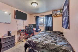 Bedroom featuring a textured ceiling and carpet