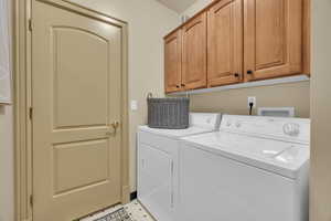 Laundry room featuring cabinets and washer and dryer