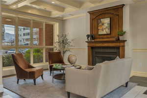 Sitting room with coffered ceiling, crown molding, a mountain view, a tile fireplace, and beam ceiling