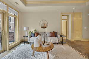 Living area with crown molding and a raised ceiling