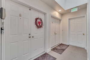 Entrance foyer with light colored carpet