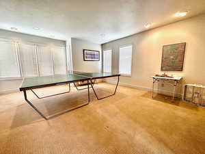 Playroom with light carpet and a textured ceiling