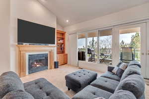 Carpeted living room with lofted ceiling