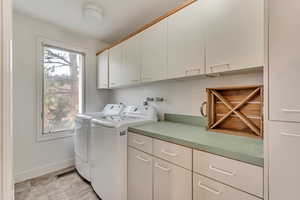 Laundry room featuring cabinets and independent washer and dryer