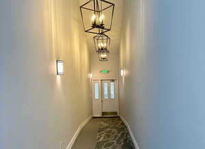 Entryway with an inviting chandelier and dark carpet