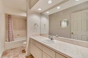 Full bathroom with shower / tub combo with curtain, vanity, and toilet