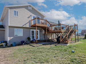 Back of property with a wooden deck and a lawn