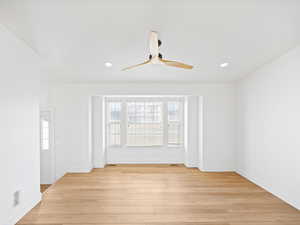 Unfurnished room with ceiling fan and light wood-type flooring