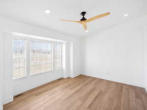 Empty room featuring ceiling fan and light wood-type flooring