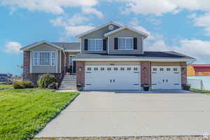 View of front of house featuring a garage and a front lawn