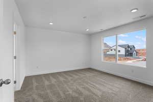 Carpeted spare room with a textured ceiling