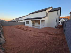 Back house at dusk featuring a patio area