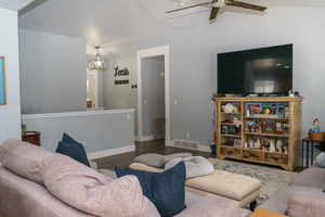 Living room featuring lofted ceiling, hardwood / wood-style flooring, and ceiling fan