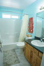 Full bathroom featuring shower / bath combination with curtain, vanity, and toilet