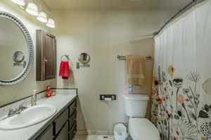 Bathroom with a shower with curtain, vanity, and toilet