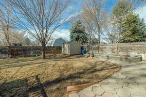 View of yard featuring a storage shed and a patio