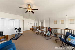 Living area featuring carpet floors, a textured ceiling, and ceiling fan