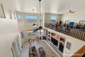 Living room featuring ceiling fan, a textured ceiling, and built in shelves