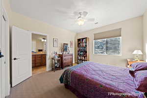 Bedroom featuring connected bathroom, light colored carpet, and ceiling fan