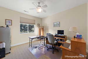 Home office featuring light carpet and ceiling fan