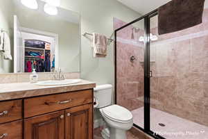 Bathroom featuring vanity, toilet, and a shower with shower door