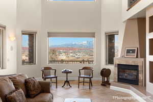 Tiled living room featuring a high ceiling, a mountain view, and a fireplace