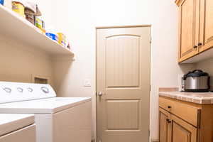 Washroom with cabinets and separate washer and dryer