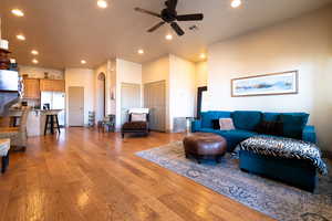 Living room with ceiling fan and light hardwood / wood-style flooring