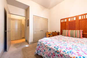 Bedroom featuring light colored carpet and a closet