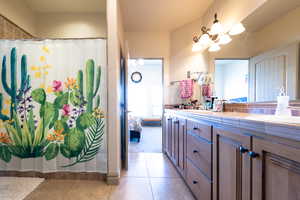 Bathroom with vanity, curtained shower, and tile patterned floors