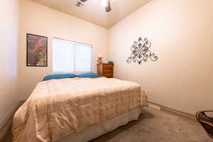 Bedroom featuring ceiling fan, lofted ceiling, and carpet floors