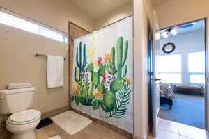 Bathroom featuring tile patterned flooring, a shower with curtain, and toilet