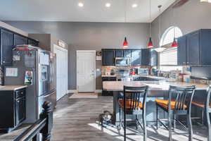 Kitchen featuring a breakfast bar area, hanging light fixtures, kitchen peninsula, stainless steel appliances, and decorative backsplash