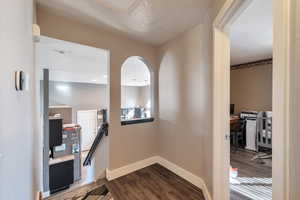 Hall with wood-type flooring and a textured ceiling