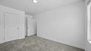 Unfurnished bedroom with light colored carpet