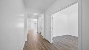 Corridor with light hardwood / wood-style flooring