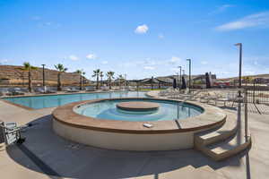 View of pool with a hot tub and a patio