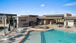 View of swimming pool featuring a hot tub and a patio area