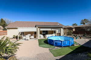 Back of property with a fenced in pool and a patio area