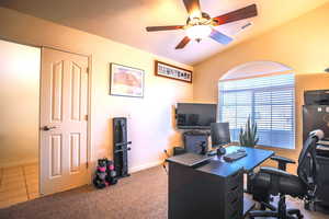 Office area featuring ceiling fan, lofted ceiling, and carpet