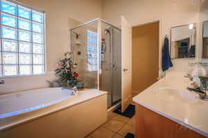 Primary Bathroom featuring tile patterned flooring, vanity, plenty of natural light, and independent shower and bath