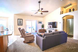 Tiled living room with lofted ceiling and ceiling fan