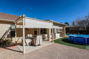 Rear view of property featuring a fenced in pool and a patio area