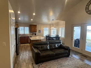 Living room featuring hardwood / wood-style flooring, a notable chandelier, and a wealth of natural light