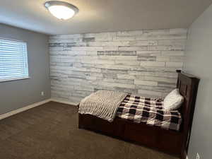 Bedroom featuring dark colored carpet